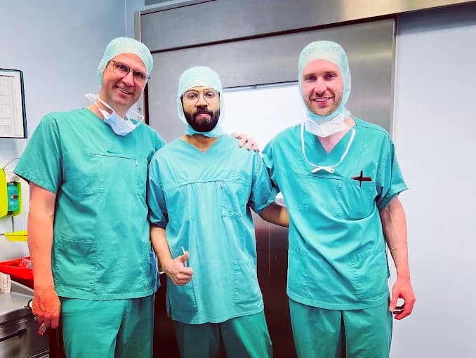 Dr. Adarsh with surgical colleagues in green scrubs